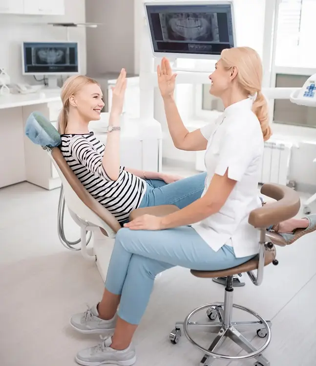 Pacients zobārstniecības krēslā dod pieci zobārstei, pozitīva pieredze un mazāks satraukums