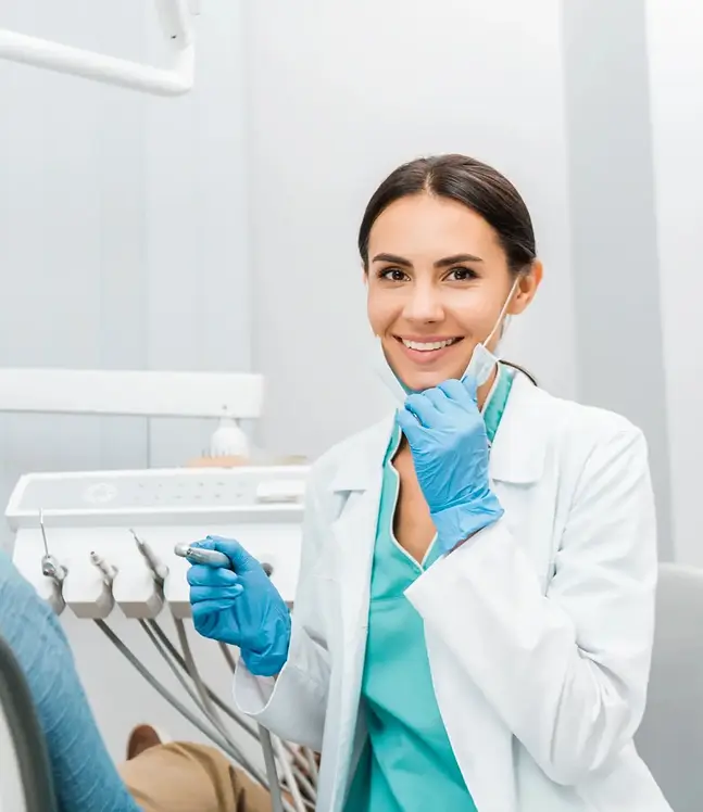 Draudzīga zobārste sarunājas ar pacientu zobārstniecības kabinetā radot mierīgu un drošu sajūtu