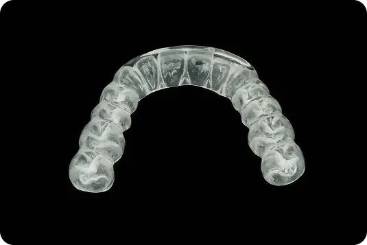 Caurspīdīga zobu aizsargkape (nakts kape) uz melna fona